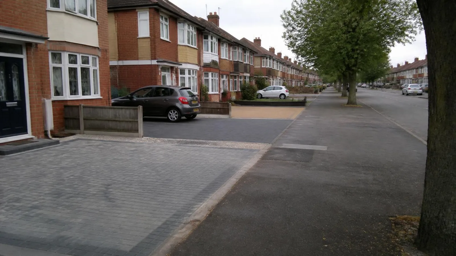 Example image: residential street of brick semis with a mix of driveway surfaces