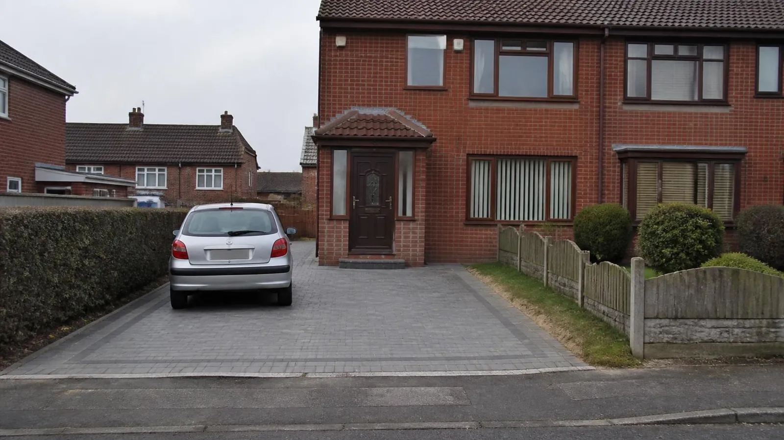 Example image: 1980s red-brick semi with a porch and a grey block-paved driveway