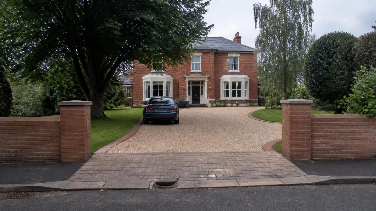 Example image: Edwardian villa with a gravel driveway between brick gate piers