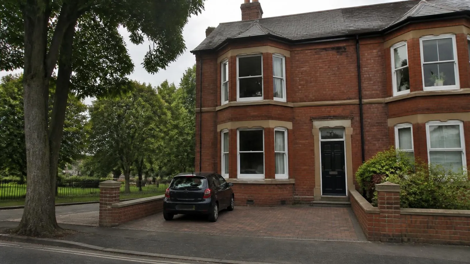 Example image: Victorian bay-fronted house with a small block-paved parking space between brick piers