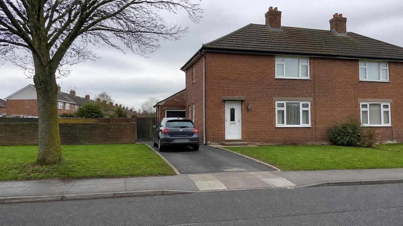 Example image: 1950s brick semi with a tarmac driveway where the front lawn used to be